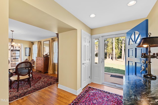 entryway with baseboards, a chandelier, wood finished floors, and recessed lighting