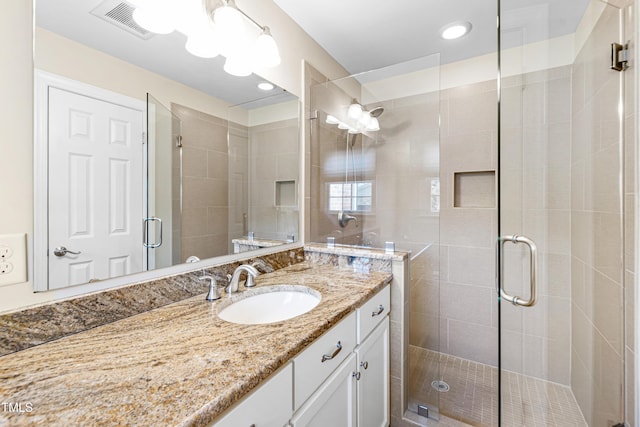 full bath with a stall shower, visible vents, and vanity