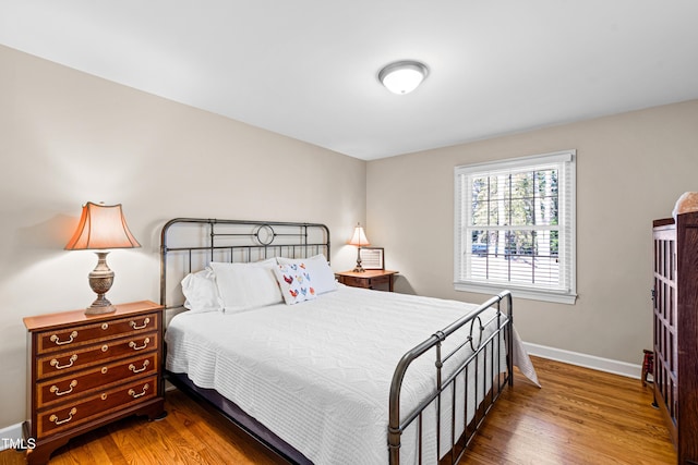 bedroom with wood finished floors and baseboards