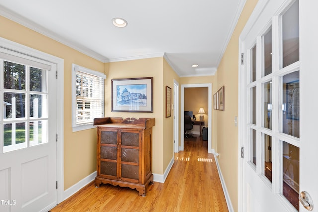 interior space featuring ornamental molding, light wood-style floors, and baseboards