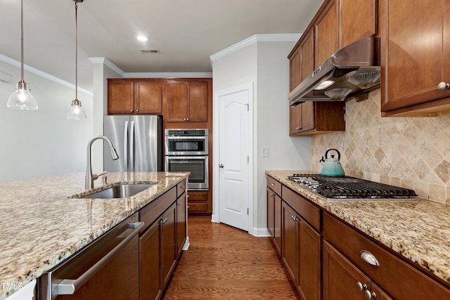 kitchen featuring crown molding, appliances with stainless steel finishes, sink, and pendant lighting