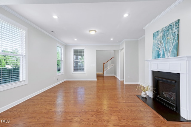 unfurnished living room featuring light wood-type flooring and ornamental molding