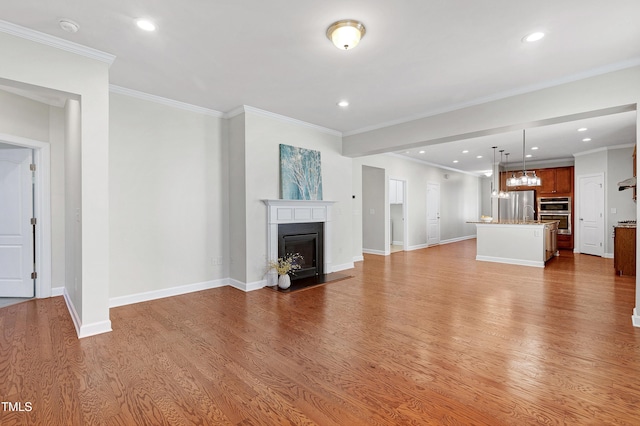 unfurnished living room featuring ornamental molding and light wood-type flooring