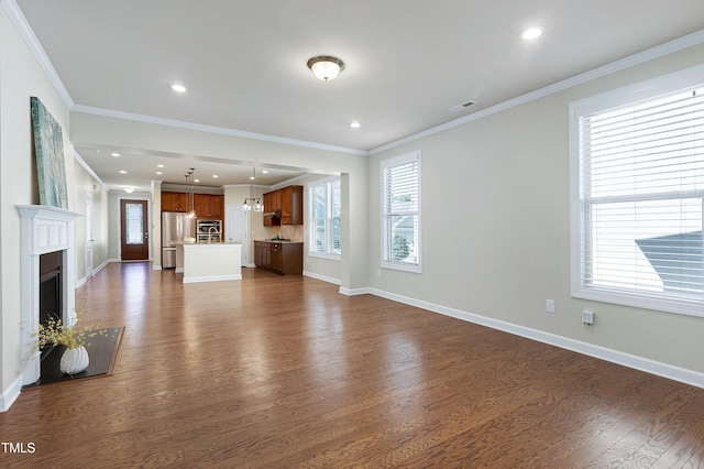 unfurnished living room featuring ornamental molding and dark wood-type flooring