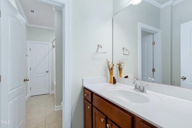 bathroom featuring tile patterned floors, ornamental molding, vanity, and a tub