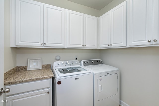 washroom featuring cabinets and washer and clothes dryer