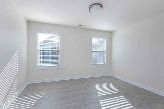 spare room featuring hardwood / wood-style floors and a wealth of natural light