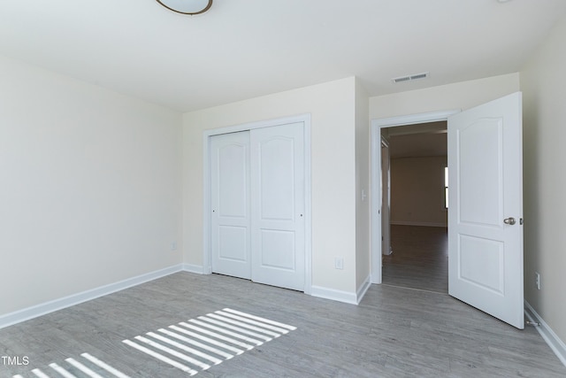 unfurnished bedroom featuring light hardwood / wood-style flooring and a closet