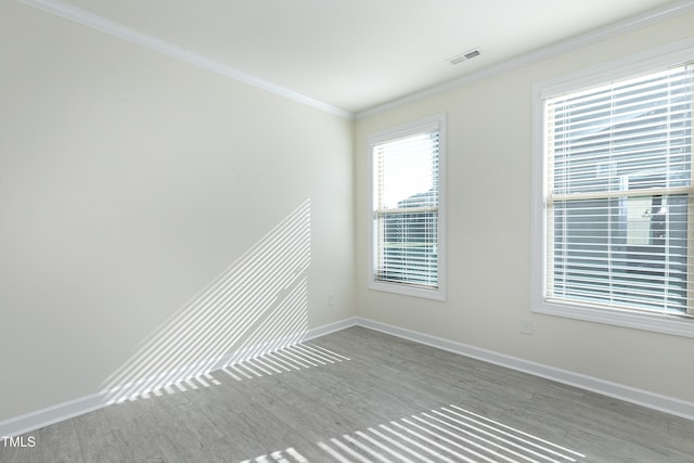 spare room featuring light hardwood / wood-style floors and crown molding