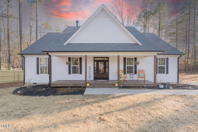 modern farmhouse style home with a shingled roof, a lawn, crawl space, covered porch, and fence