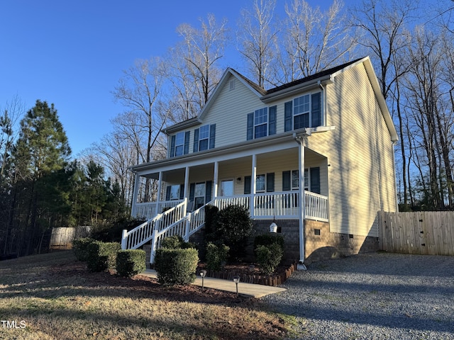 view of front of house featuring a porch, crawl space, fence, and gravel driveway