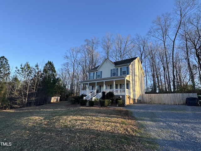 view of front facade with covered porch and gravel driveway