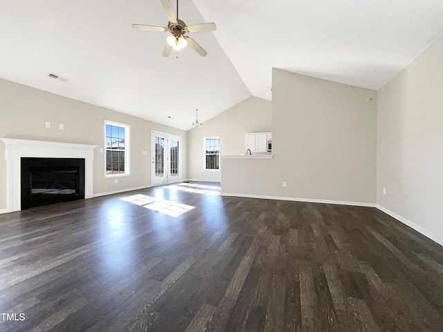 unfurnished living room with ceiling fan, dark wood-style flooring, a fireplace, visible vents, and baseboards