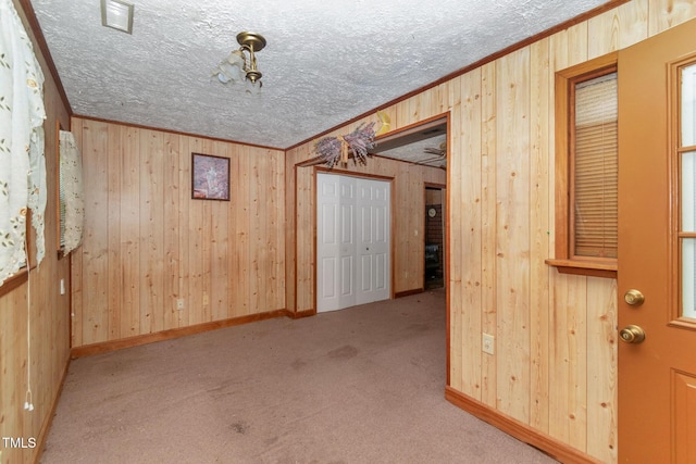 811 Queens St NW, Lenoir, NC 28645 - carpeted empty room with crown molding, wooden walls, and a textured ceiling