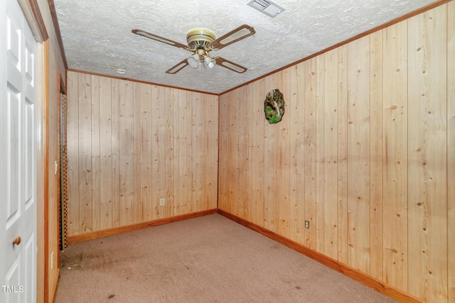 811 Queens St NW, Lenoir, NC 28645 - unfurnished room with ceiling fan, wooden walls, carpet flooring, ornamental molding, and a textured ceiling