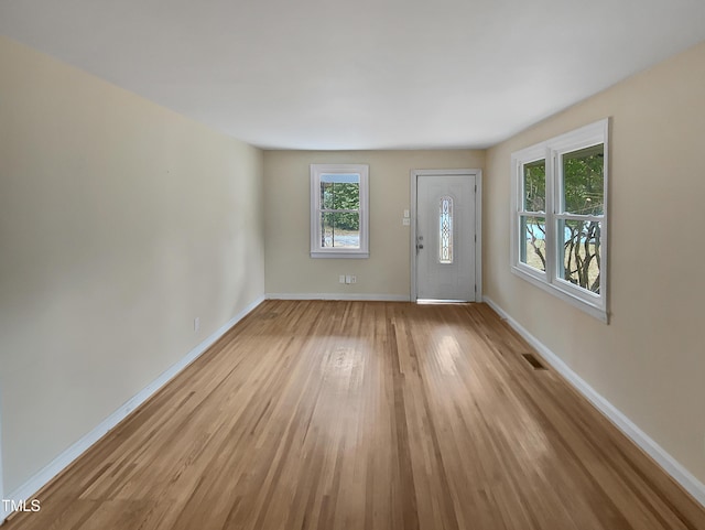 entrance foyer with light wood-style flooring, visible vents, and baseboards