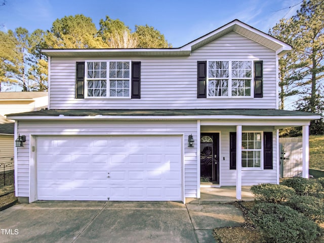 traditional-style house with a garage, concrete driveway, and covered porch