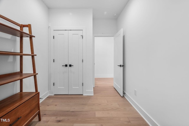 hall featuring baseboards and light wood-style floors