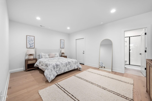 bedroom with arched walkways, recessed lighting, baseboards, light wood-type flooring, and ensuite bath