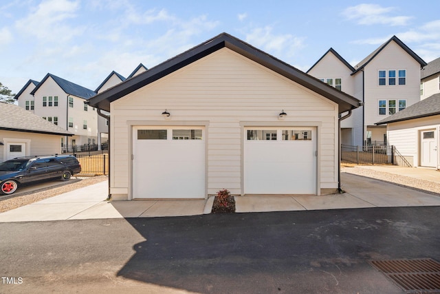 detached garage with a residential view and fence