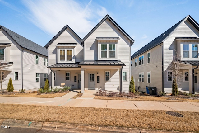 modern farmhouse style home featuring a standing seam roof, covered porch, and metal roof