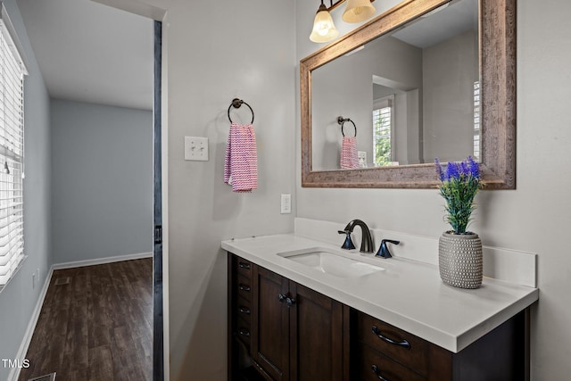 bathroom featuring vanity, baseboards, and wood finished floors