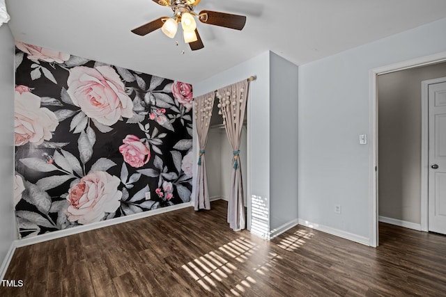 empty room featuring ceiling fan, wood finished floors, and baseboards