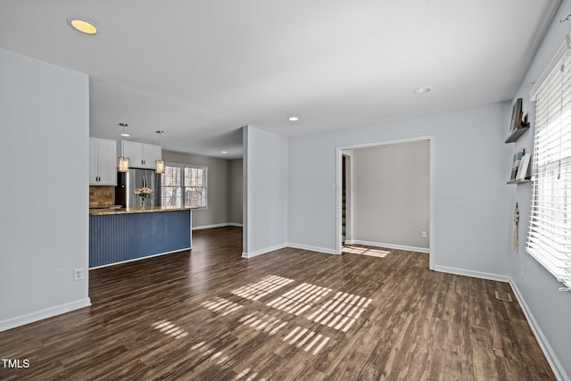 unfurnished living room with dark wood-style flooring, recessed lighting, visible vents, and baseboards