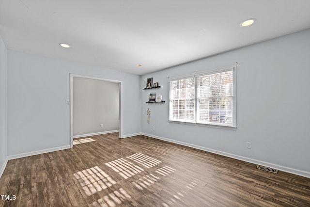 empty room featuring baseboards, visible vents, wood finished floors, and recessed lighting