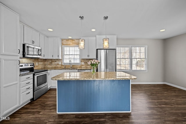 kitchen with dark wood-style floors, a kitchen island, stainless steel appliances, and backsplash