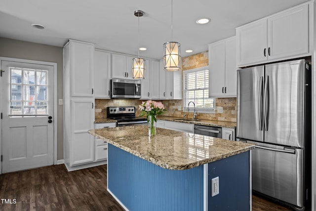 kitchen with white cabinets, dark wood-style floors, stainless steel appliances, and a sink