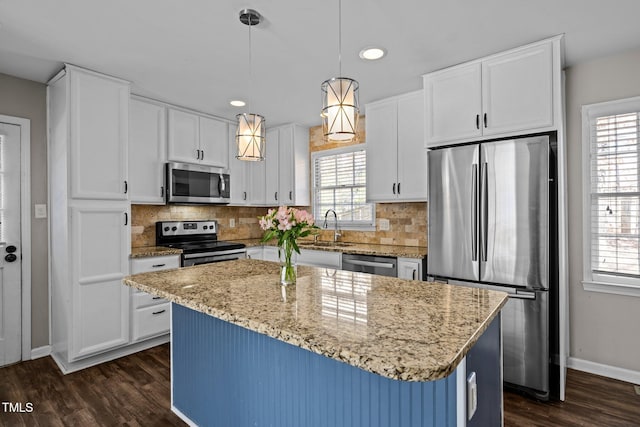 kitchen with stainless steel appliances, a healthy amount of sunlight, and dark wood finished floors