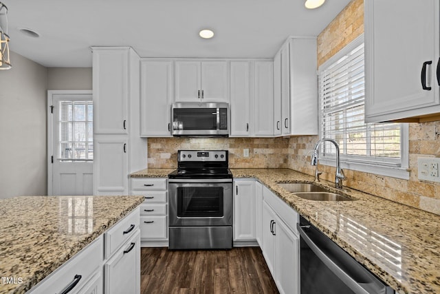 kitchen featuring a wealth of natural light, decorative backsplash, stainless steel appliances, and a sink