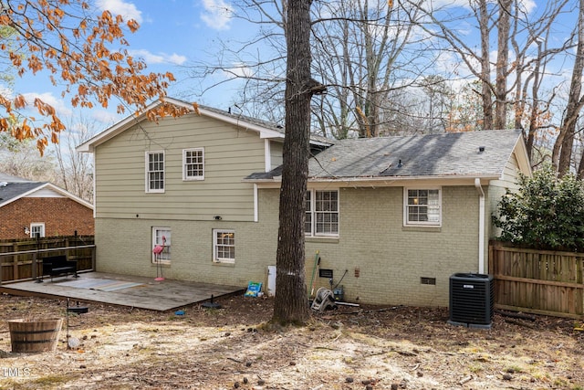 rear view of house featuring crawl space, fence, a deck, central air condition unit, and brick siding