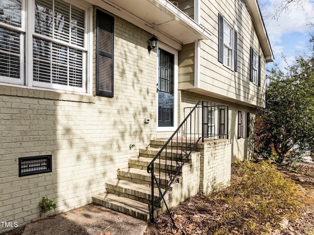 view of exterior entry featuring brick siding