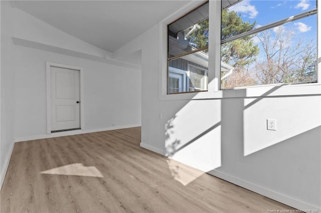 unfurnished room with light hardwood / wood-style flooring and lofted ceiling