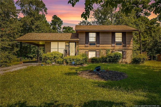 split level home featuring a lawn and a carport