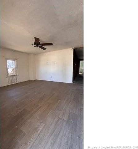 unfurnished room with ceiling fan and dark hardwood / wood-style flooring