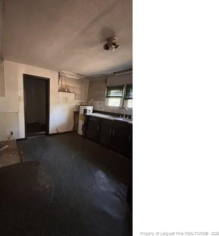 kitchen featuring water heater, sink, and a textured ceiling