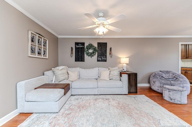 living room with ceiling fan, crown molding, and hardwood / wood-style floors