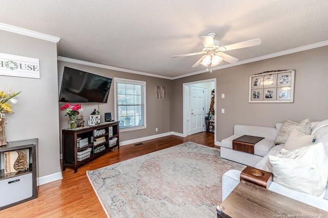 living room with ceiling fan, light hardwood / wood-style flooring, crown molding, and a textured ceiling