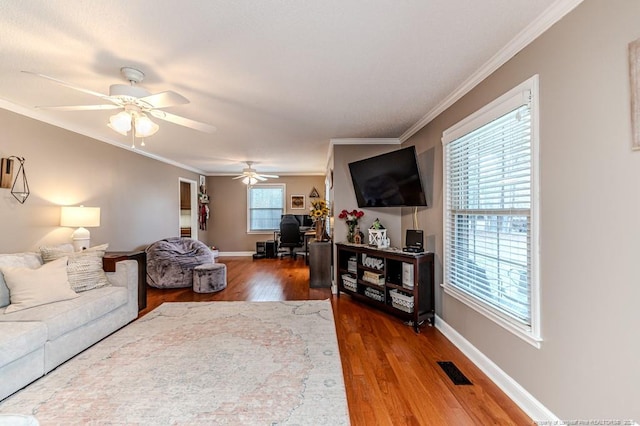 living room with ornamental molding, hardwood / wood-style flooring, and ceiling fan