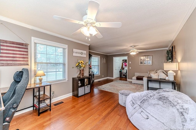 bedroom featuring a textured ceiling, ornamental molding, hardwood / wood-style floors, and ceiling fan