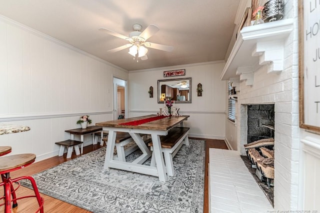 game room featuring a fireplace, hardwood / wood-style flooring, crown molding, and ceiling fan