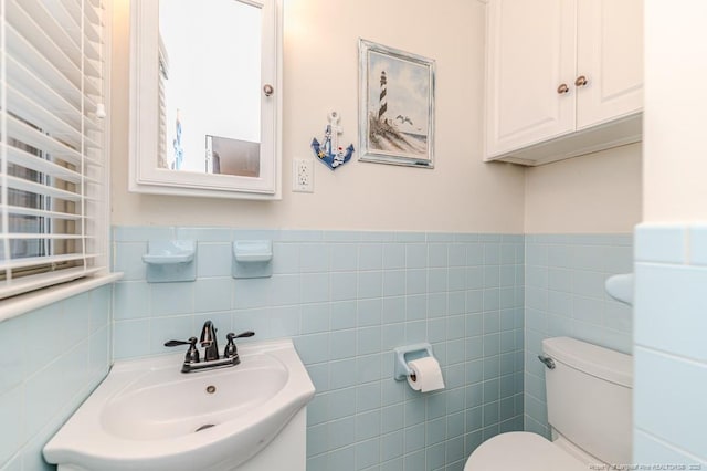 bathroom with sink, tile walls, and toilet