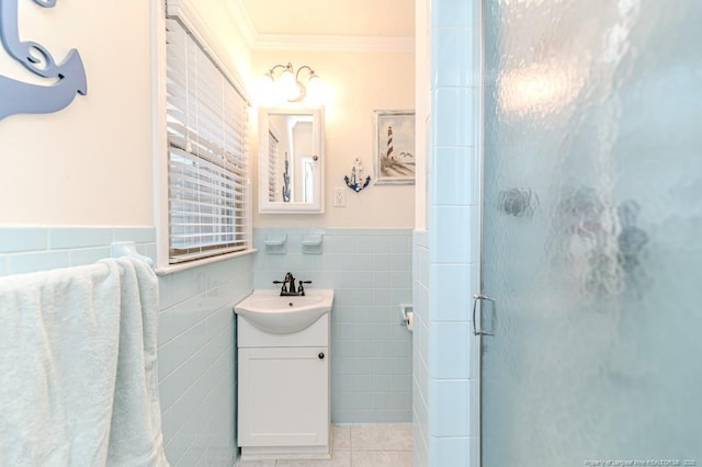 bathroom with tile walls, vanity, an enclosed shower, tile patterned floors, and ornamental molding