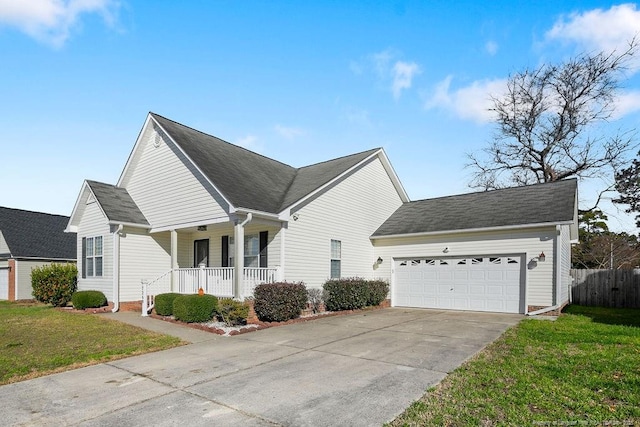 view of side of property with covered porch, a garage, and a yard