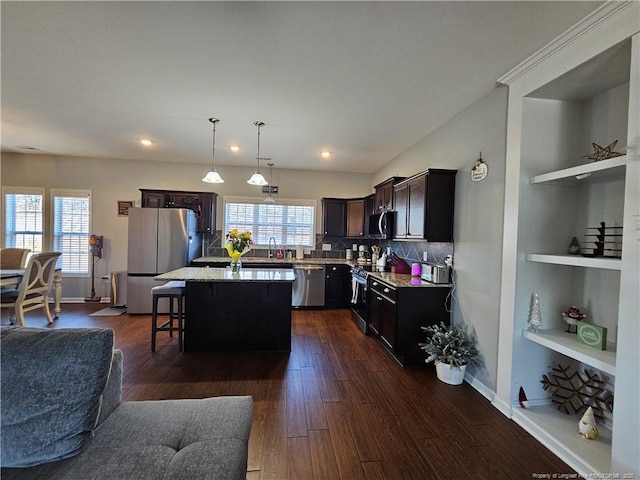 kitchen featuring dark hardwood / wood-style flooring, stainless steel appliances, dark brown cabinetry, and a center island