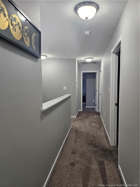 corridor featuring dark colored carpet