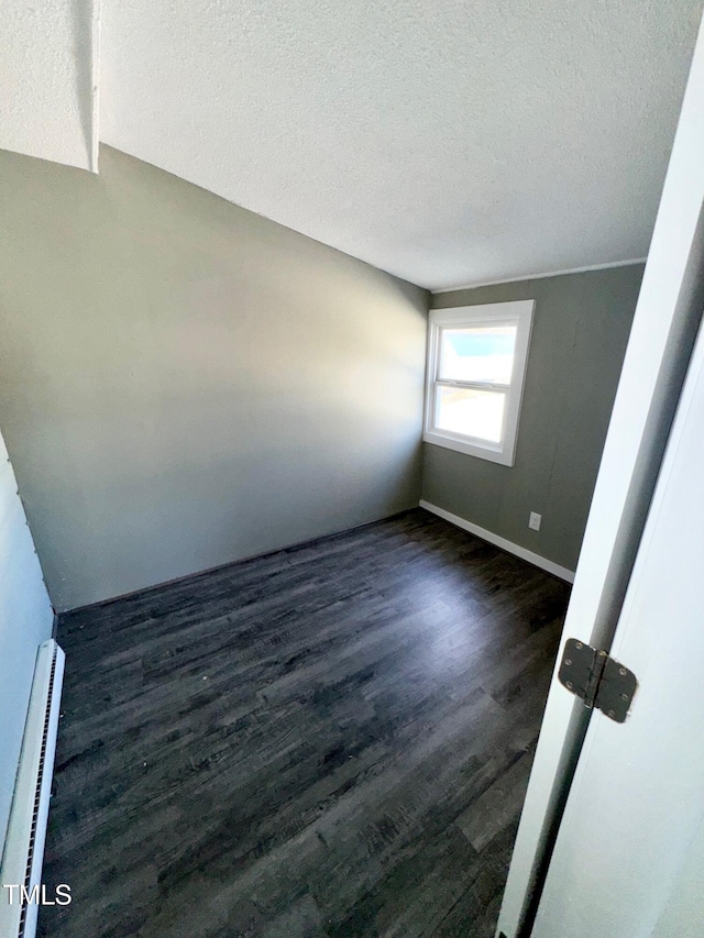 212 Craig Ave, Henderson, NC 27537 - unfurnished room featuring dark wood-style floors, baseboards, a textured ceiling, and baseboard heating